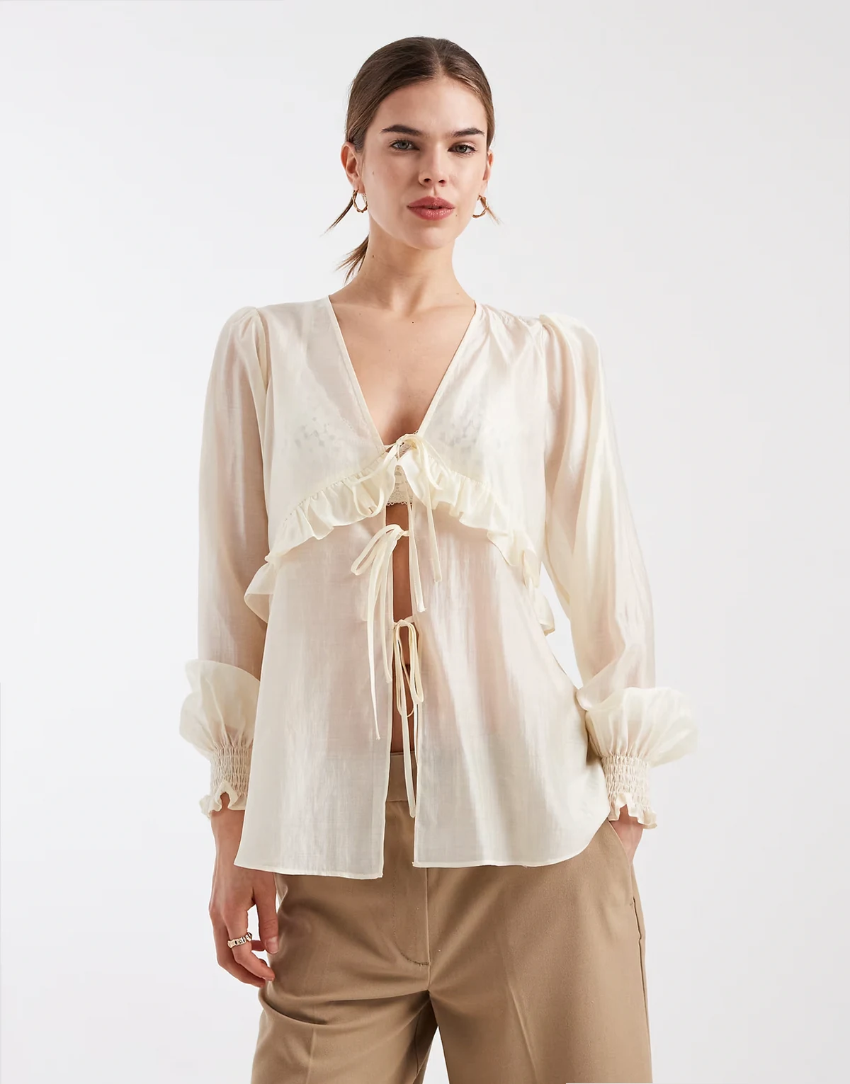 – Kremowa bluzka z delikatnie prześwitującego szyfonu z rozcięciem z przodu i falbanką