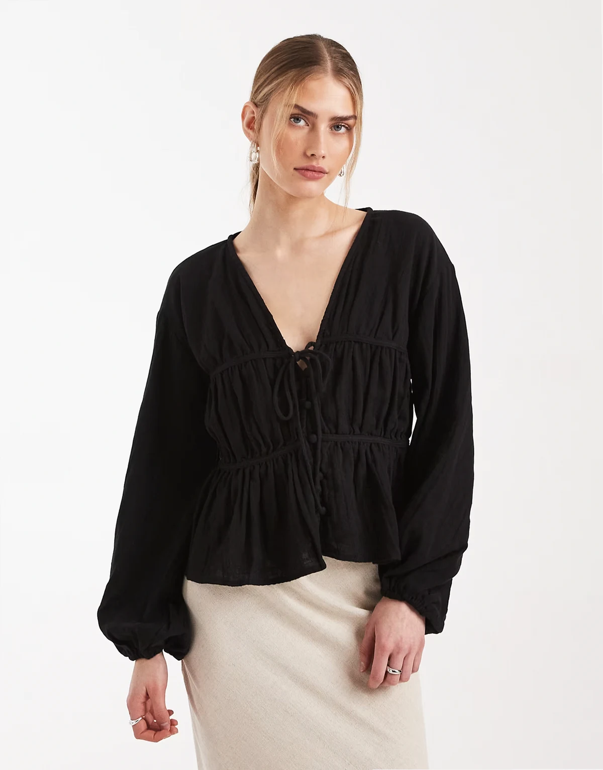 – Luźny czarny top z długimi rękawami i zapięciem na guziki z przodu