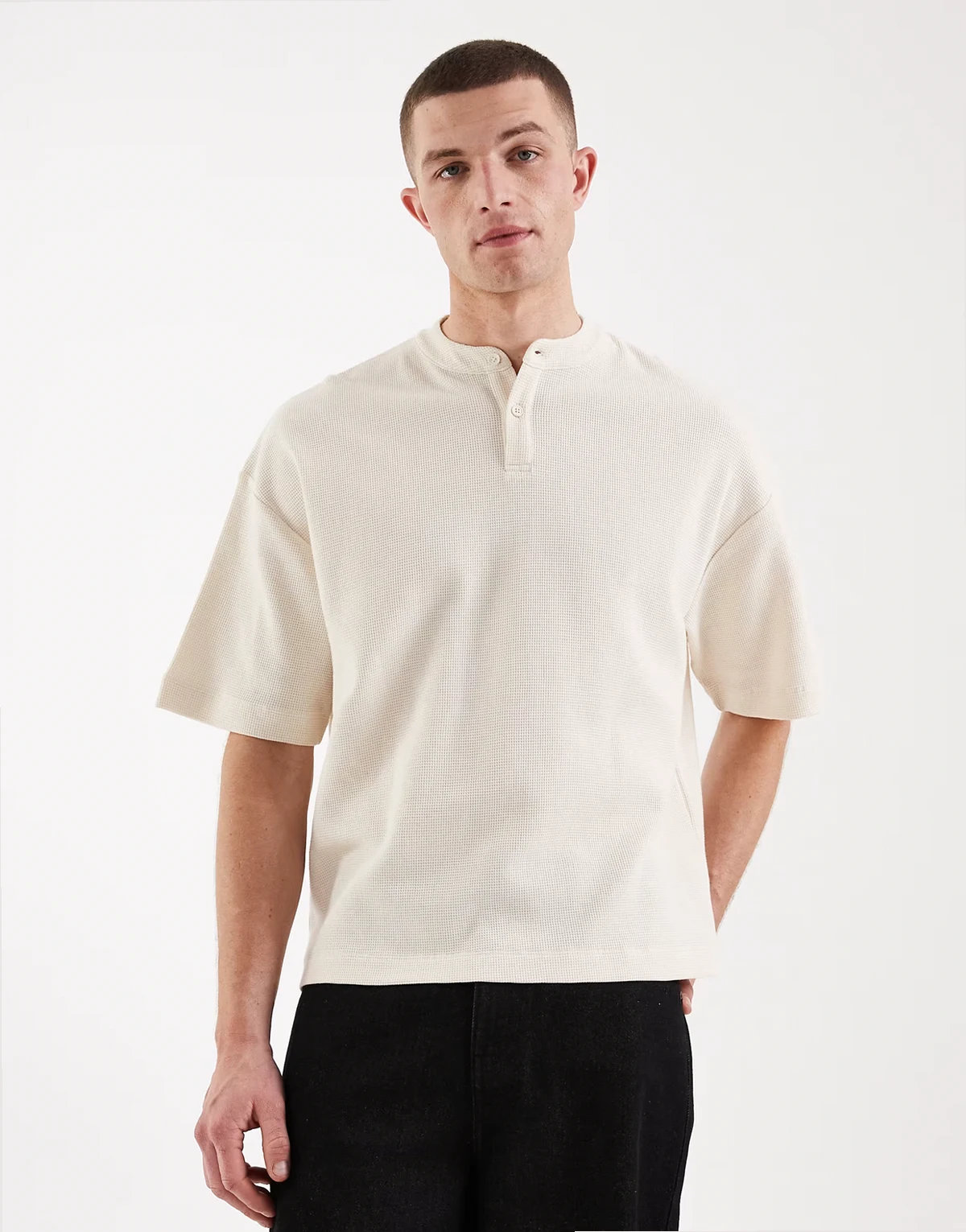 – Kremowy T-shirt oversize o pudełkowym kroju z dekoltem typu henley o waflowej fakturze