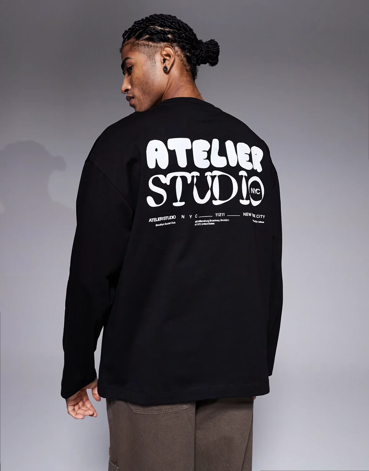 – Czarny T-shirt oversize z długim rękawem i grafiką „Atelier Studio”