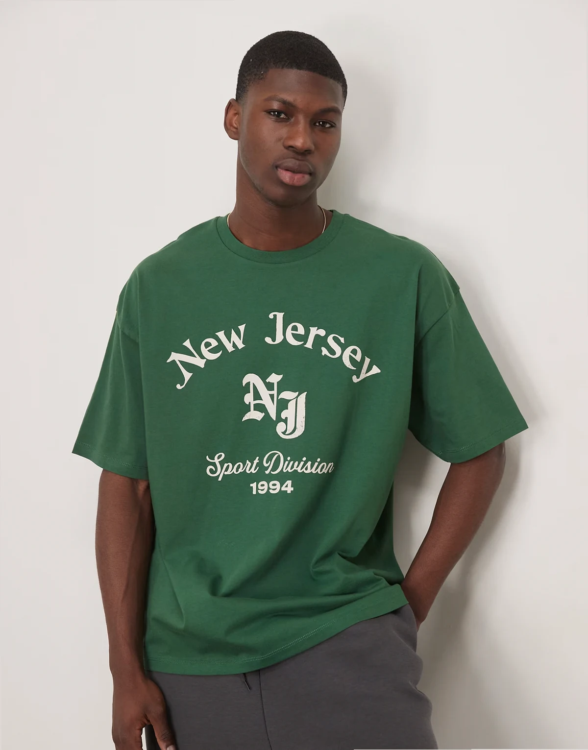 – Ciemnozielony T-shirt oversize z grafiką z nazwą miasta z przodu