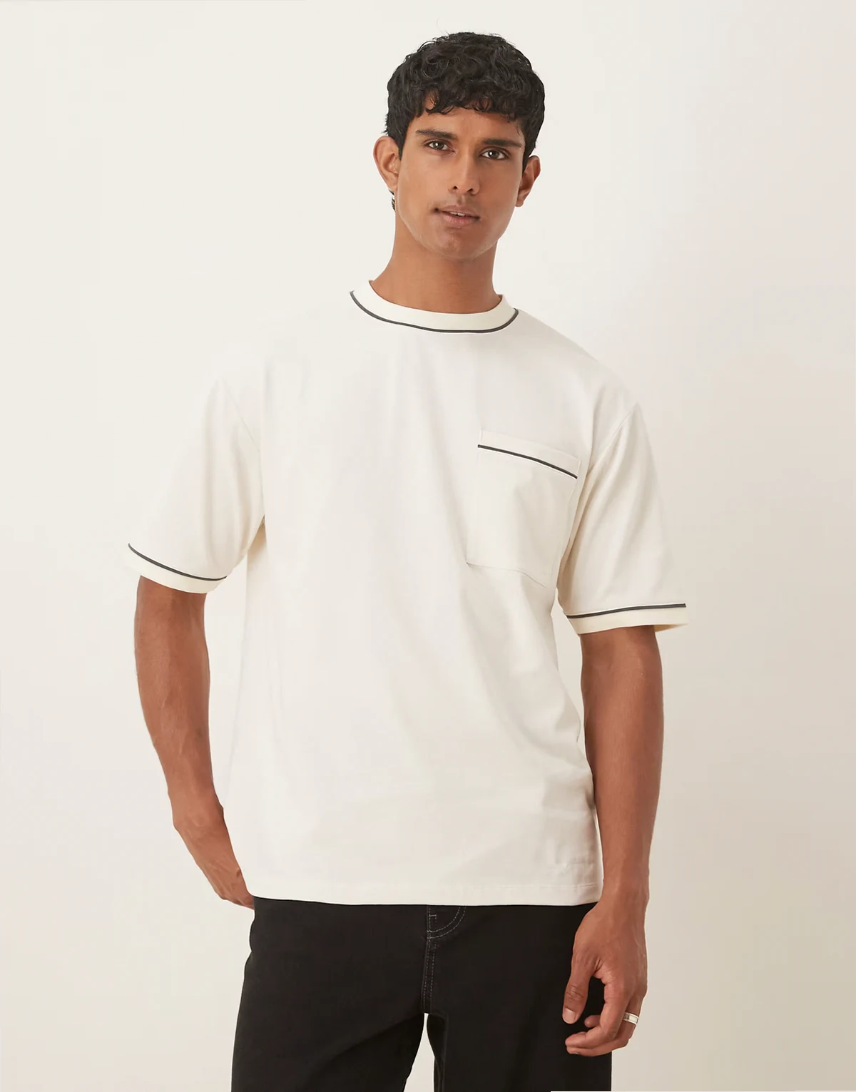 – Kremowy T-shirt o luźnym kroju z kontrastową lamówką z grubej dzianiny o gramaturze 240g/m²
