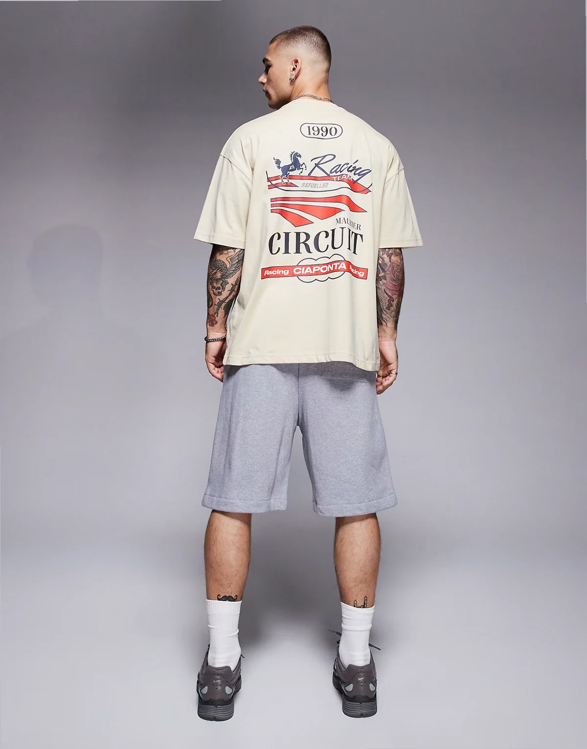 – Beżowy T-shirt oversize z grafiką z motywem wyścigów
