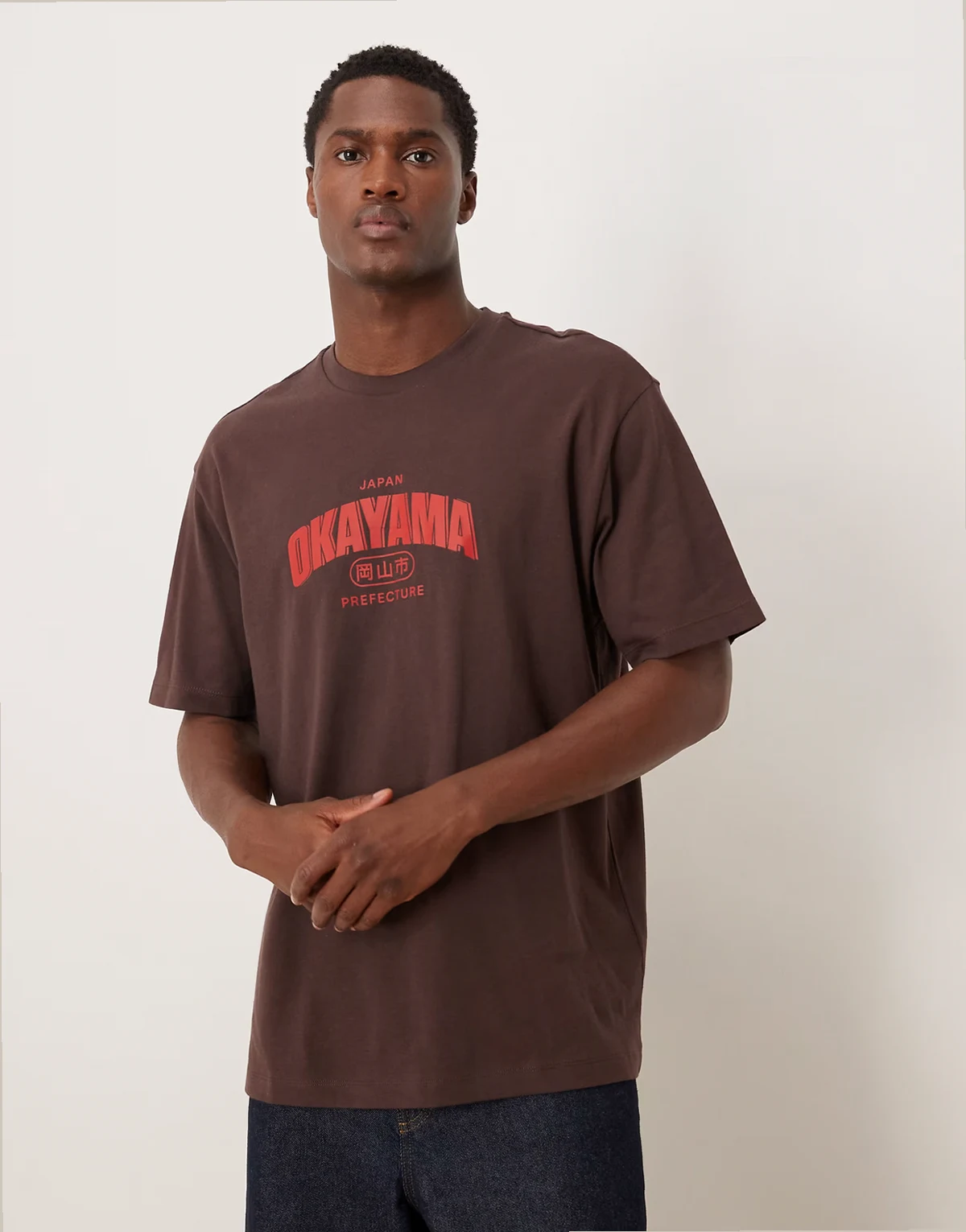 – Brązowy luźny T-shirt z nadrukiem z motywem miastem