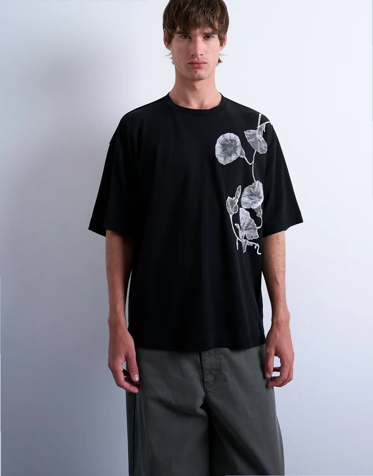 – Czarny, luźny T-shirt z haftowanym, kwiatowym motywem
