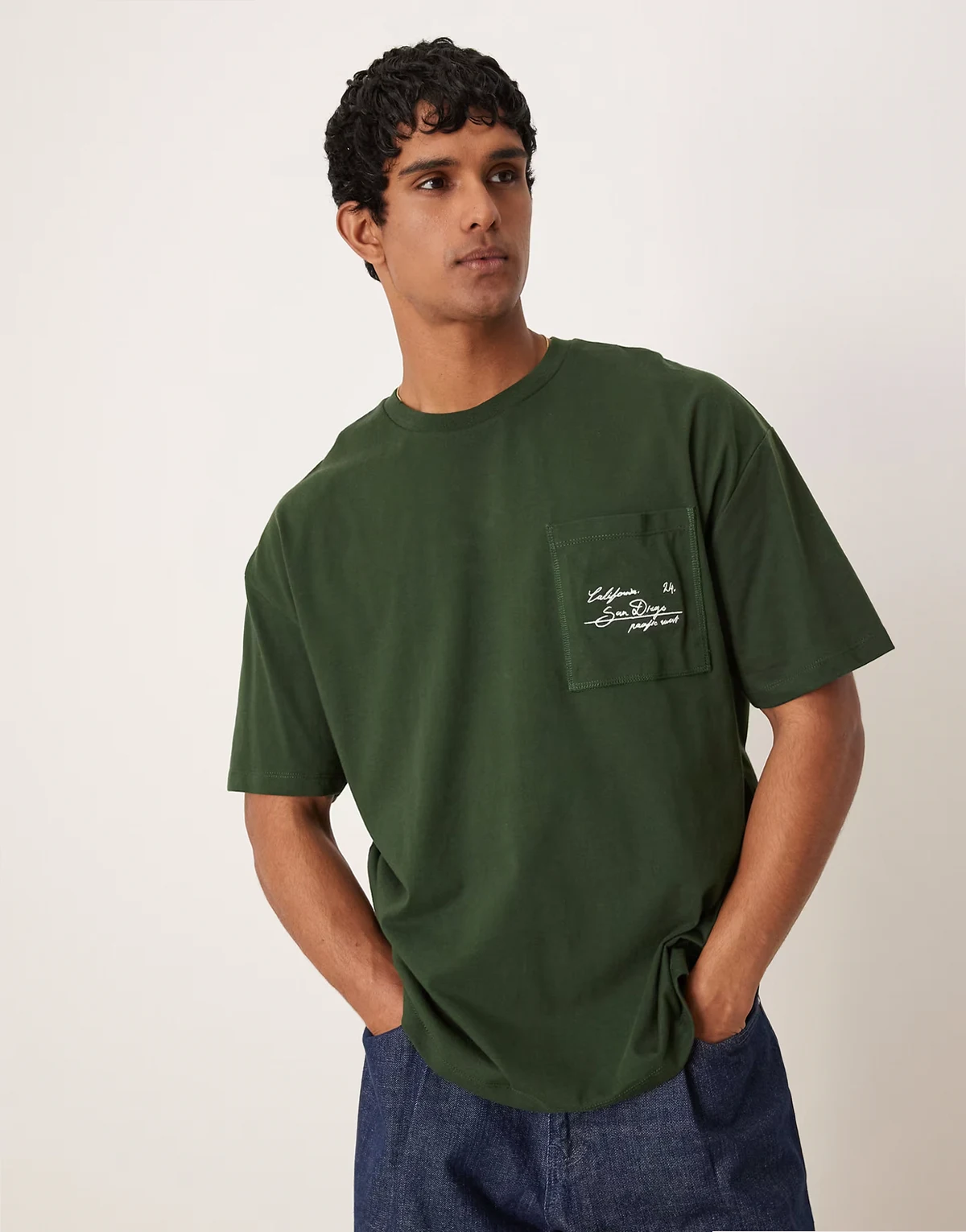 – Zielony T-shirt oversize z haftowaną nazwą miasta na kieszeni