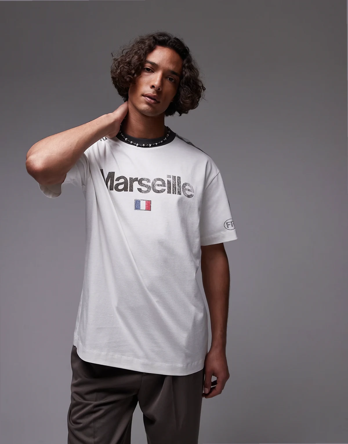 – Biały, luźny T-shirt z lamówką i napisem „Marseille”