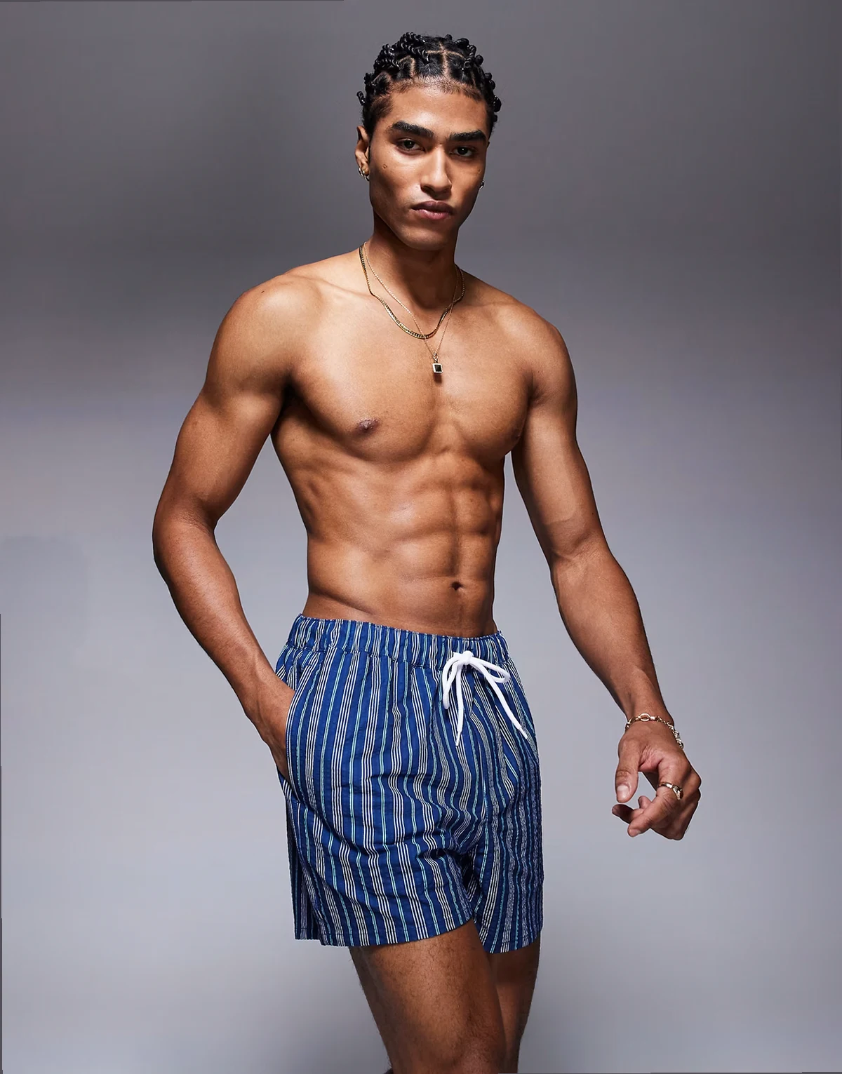 – Kurze, blau gestreifte Badeshorts