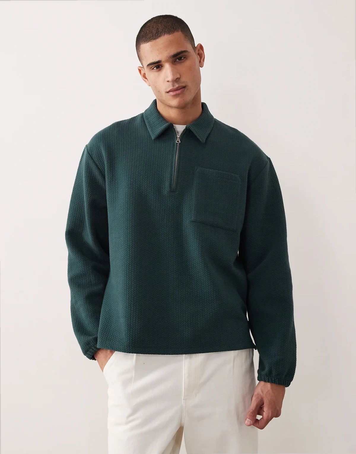 – Ciemnozielona bluza oversize z kołnierzykiem polo i zamkiem pod szyją o bąbelkowej fakturze