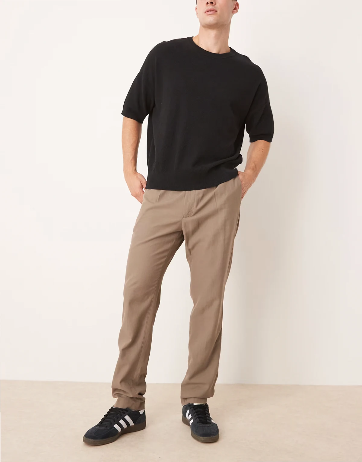 – Brązowe eleganckie zwężane spodnie z zakładkami z przodu