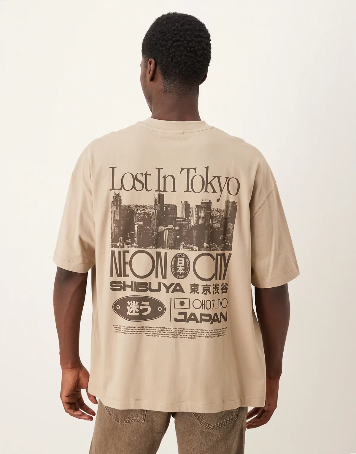 – Beżowy T-shirt oversize z grafiką z napisem Tokyo
