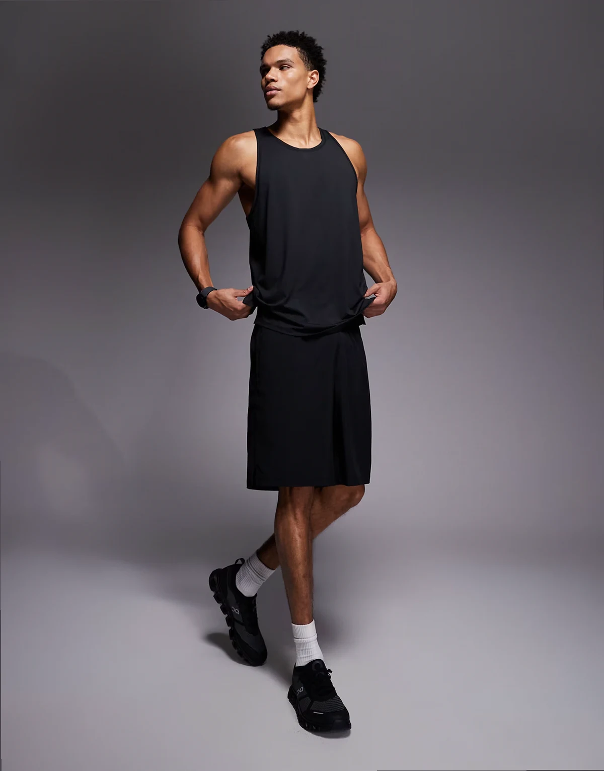 – Czarne szybkoschnące luźne szorty treningowe o długości 25 cm z kieszeniami zapinanymi na zamek