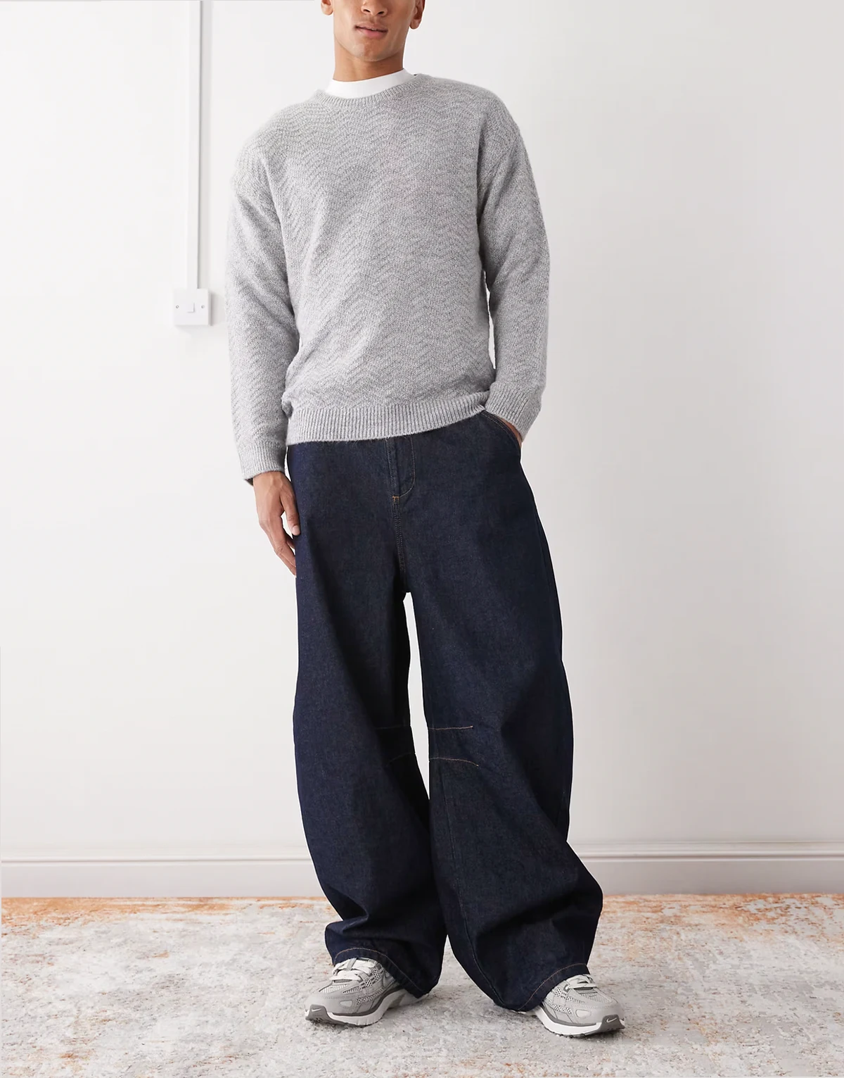 – Ciemnoniebieskie jeansy z poszerzanymi nogawkami i kontrastowymi szwami