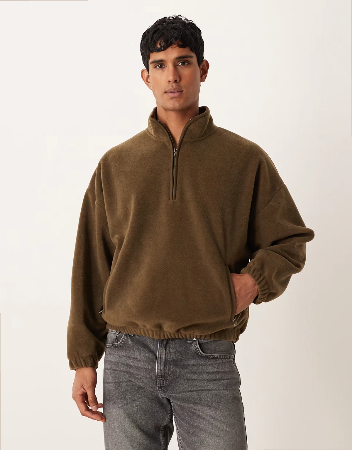 – Bluza w kolorze khaki o luźnym kroju, z obniżoną linią ramion i zapięciem na zamek pod szyją