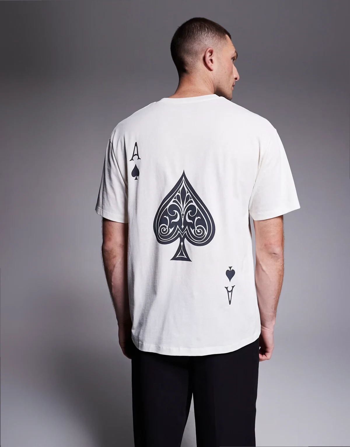– Kremowy T-shirt oversize z nadrukiem z asem pik na plecach