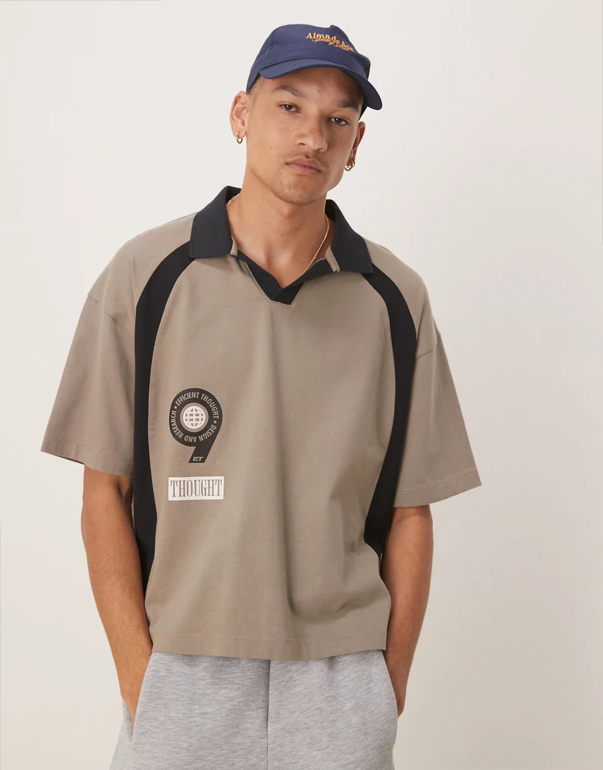 – Kastiges Oversize-Poloshirt in Beige mit Sport-Grafikprints auf Vorder- und Rückseite