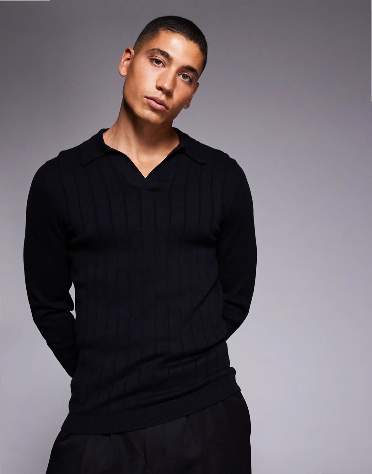 – Czarna prążkowana dzianinowa koszulka polo o kroju podkreślającym sylwetkę z długimi rękawami i wycięciem przy szyi