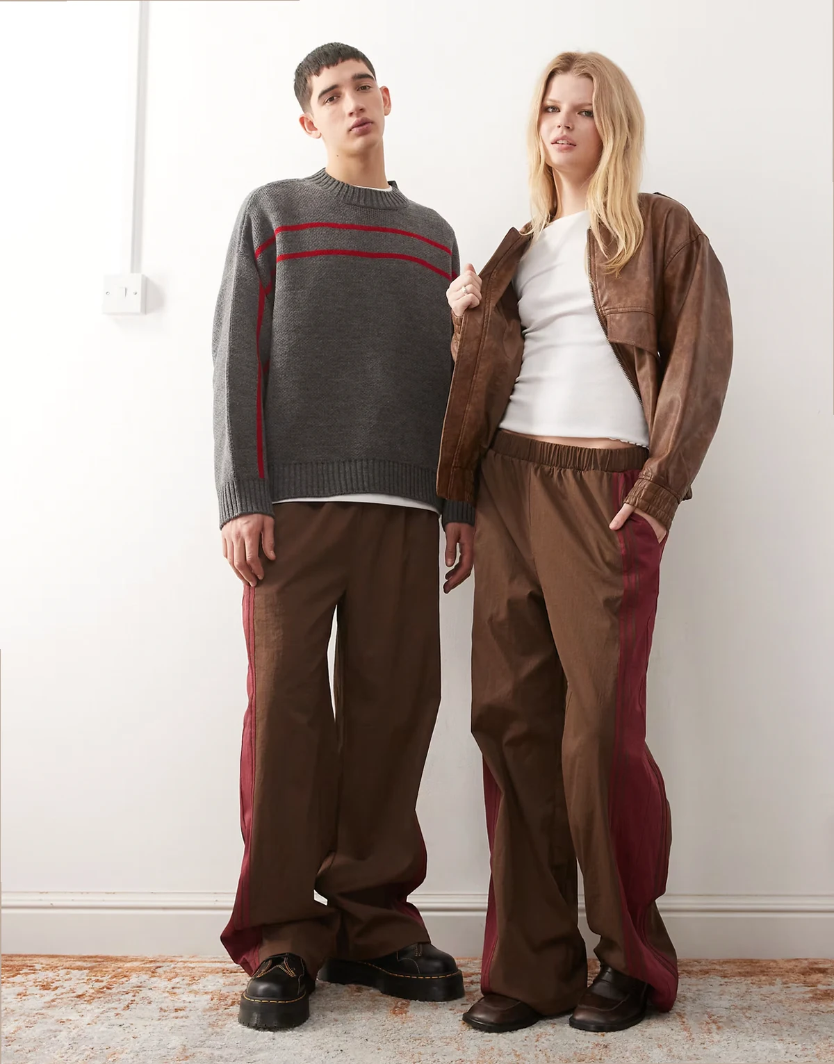 Unisex – Brązowe wciągane spodnie z bordowym paskiem z boku