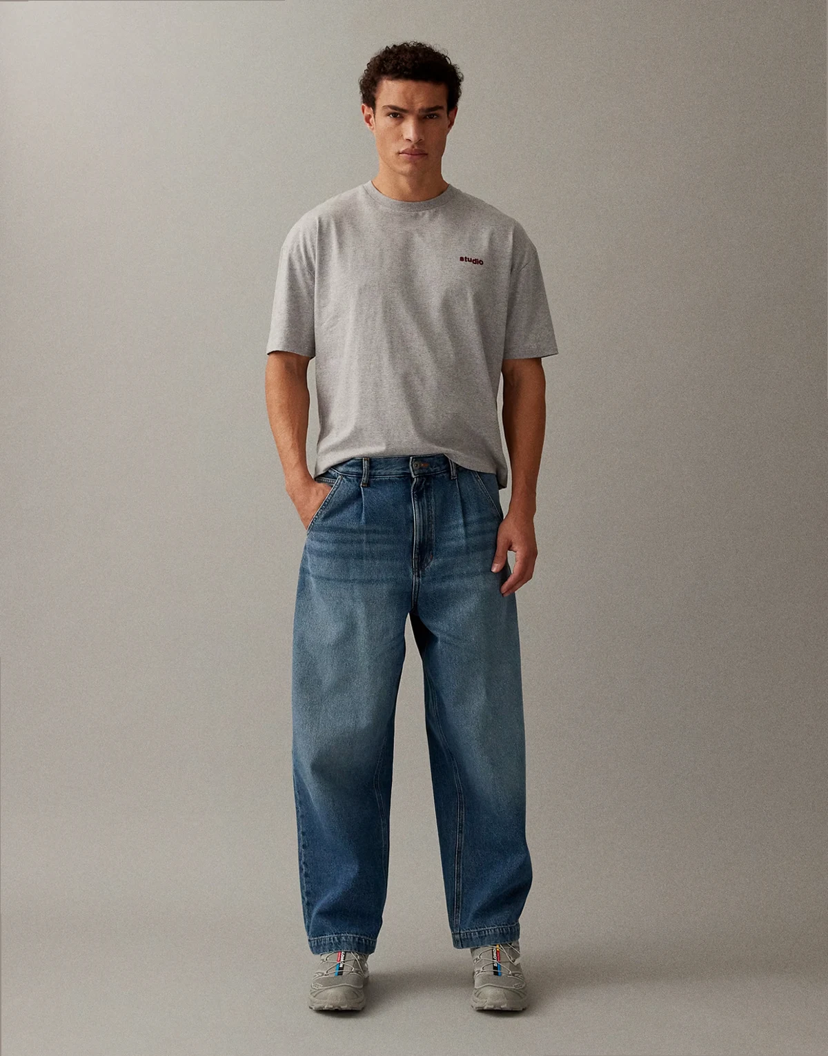 – Niebieskie, luźne jeansy ze zwężanymi nogawkami i zakładkami