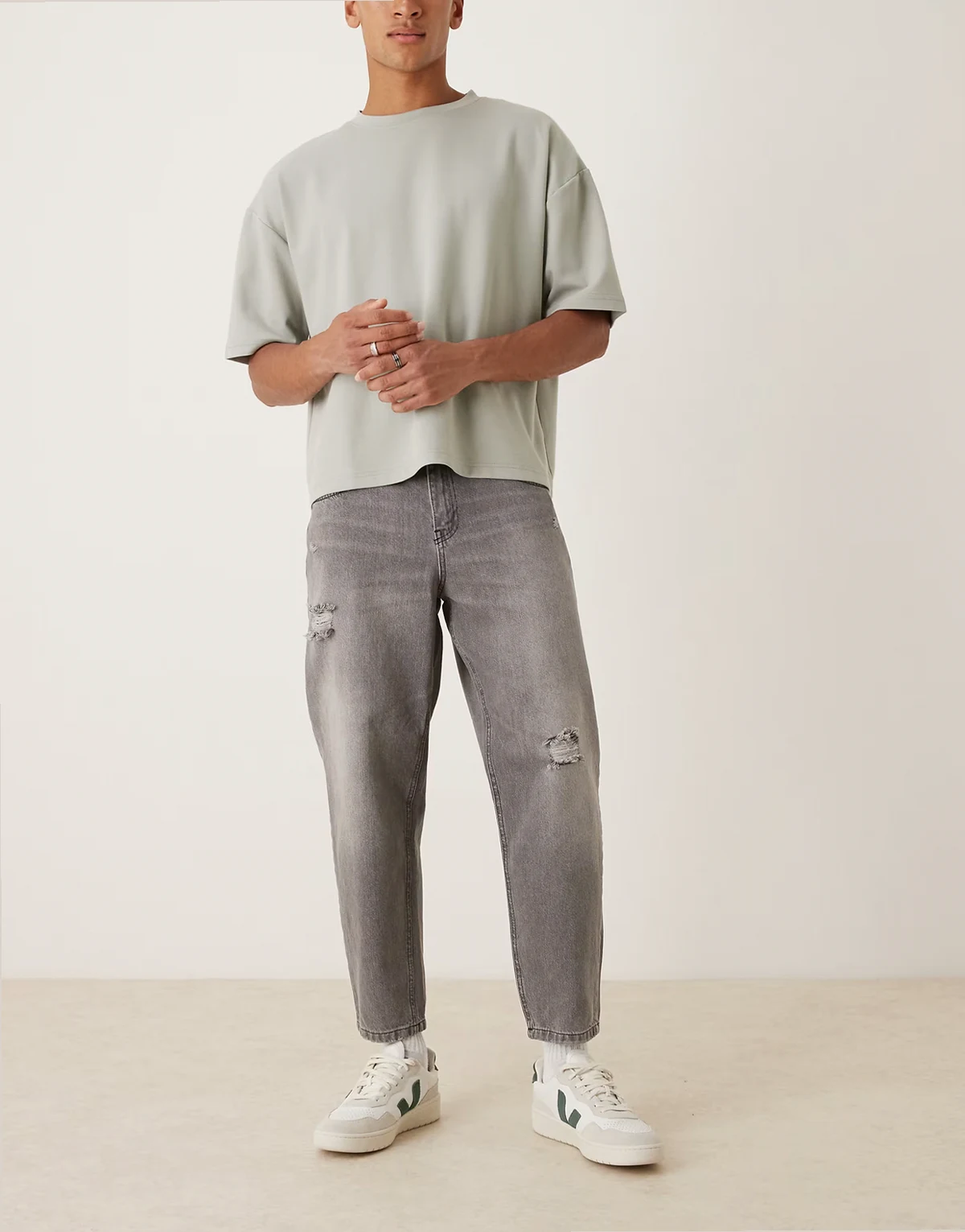 – Czarne luźne jeansy ze zwężanymi nogawkami, efektem sprania i rozdarciami