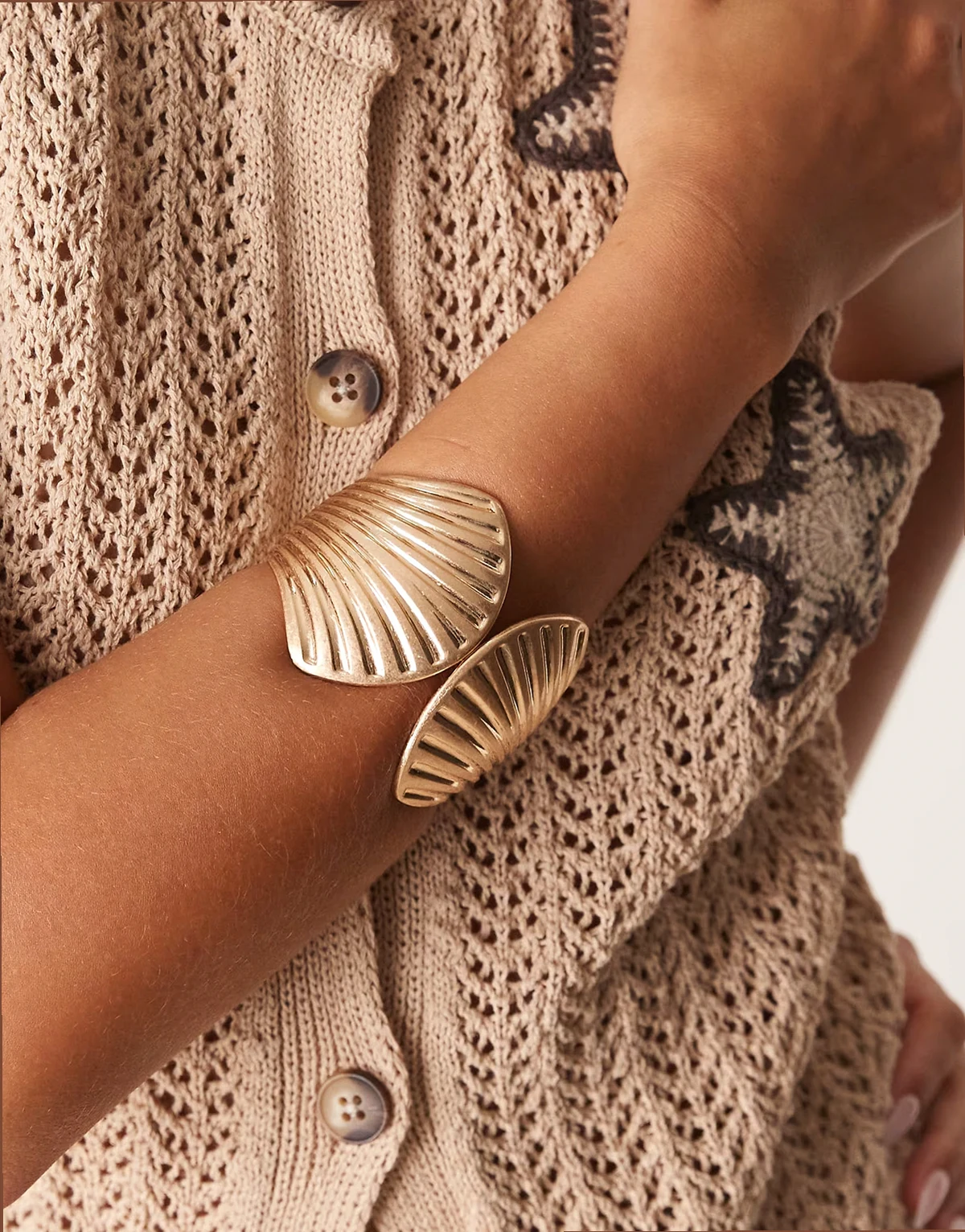 large cuff bracelet with shell design in brushed gold tone