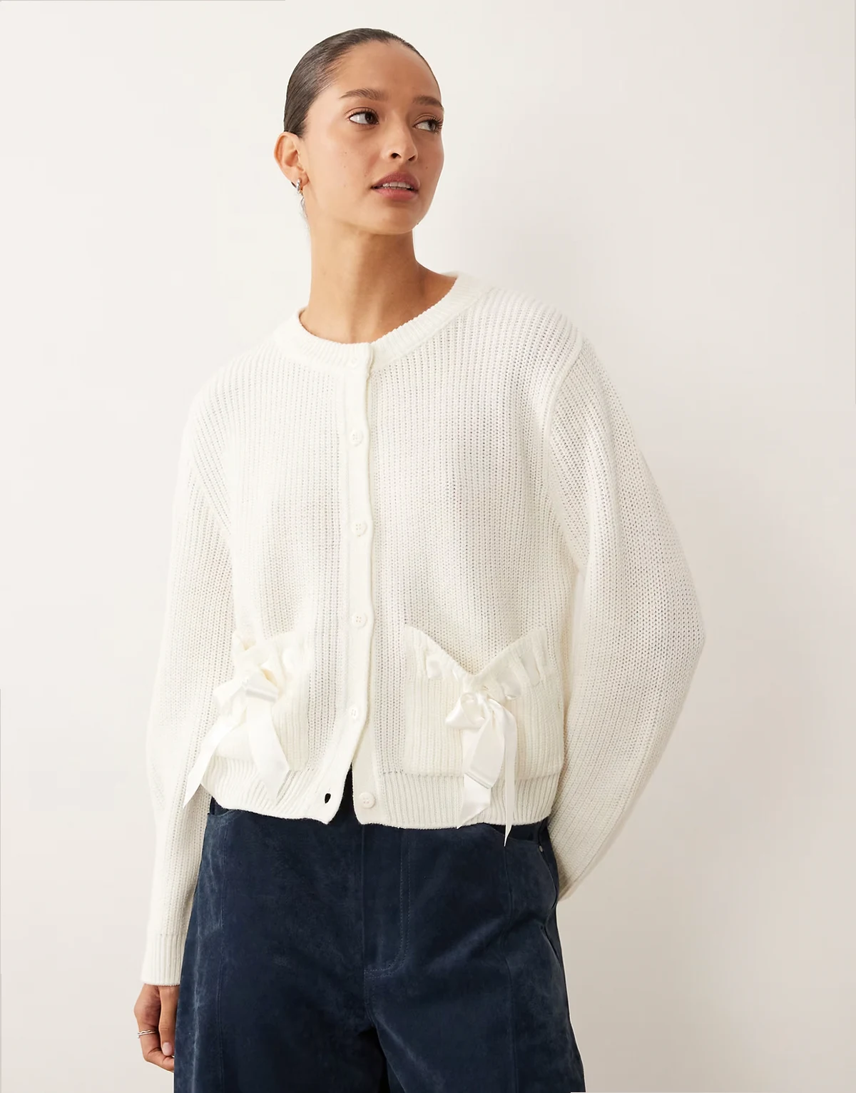 – Strickjacke mit Rundhalsausschnitt und Schleifenverzierung an den Taschen
