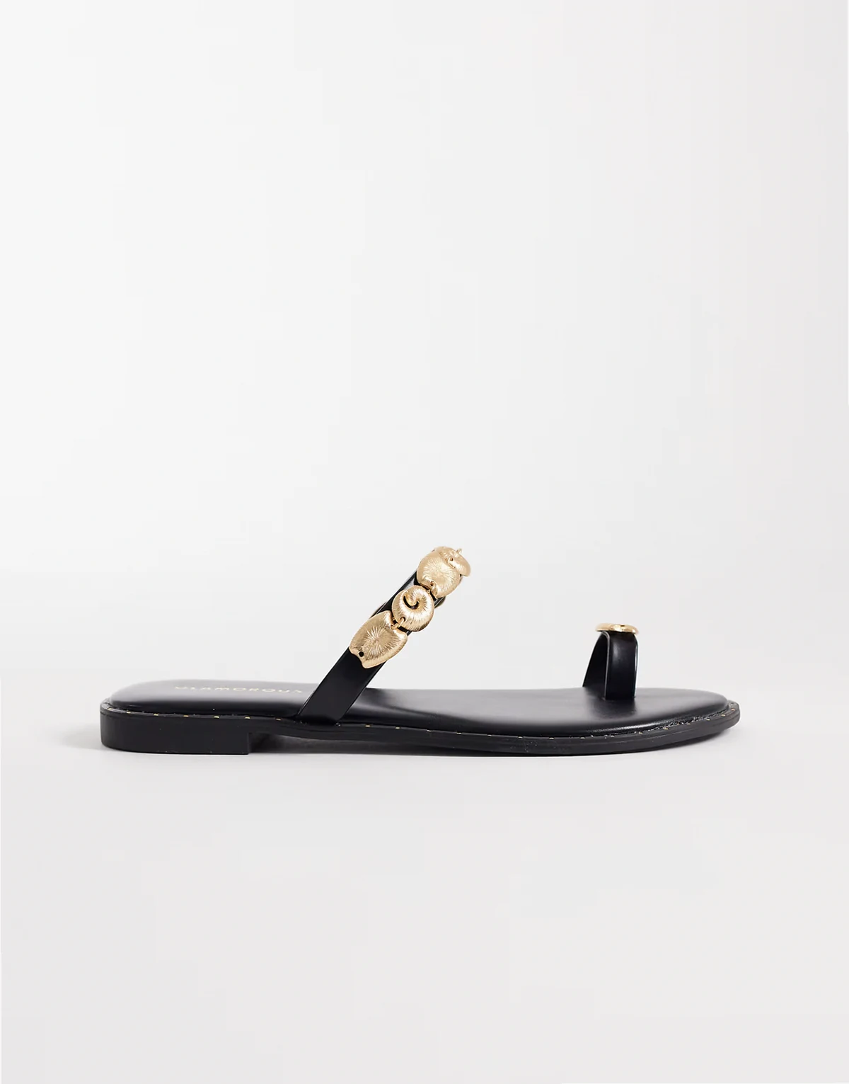 – Flache Sandalen in Schwarz mit goldfarbenen Muscheldetails