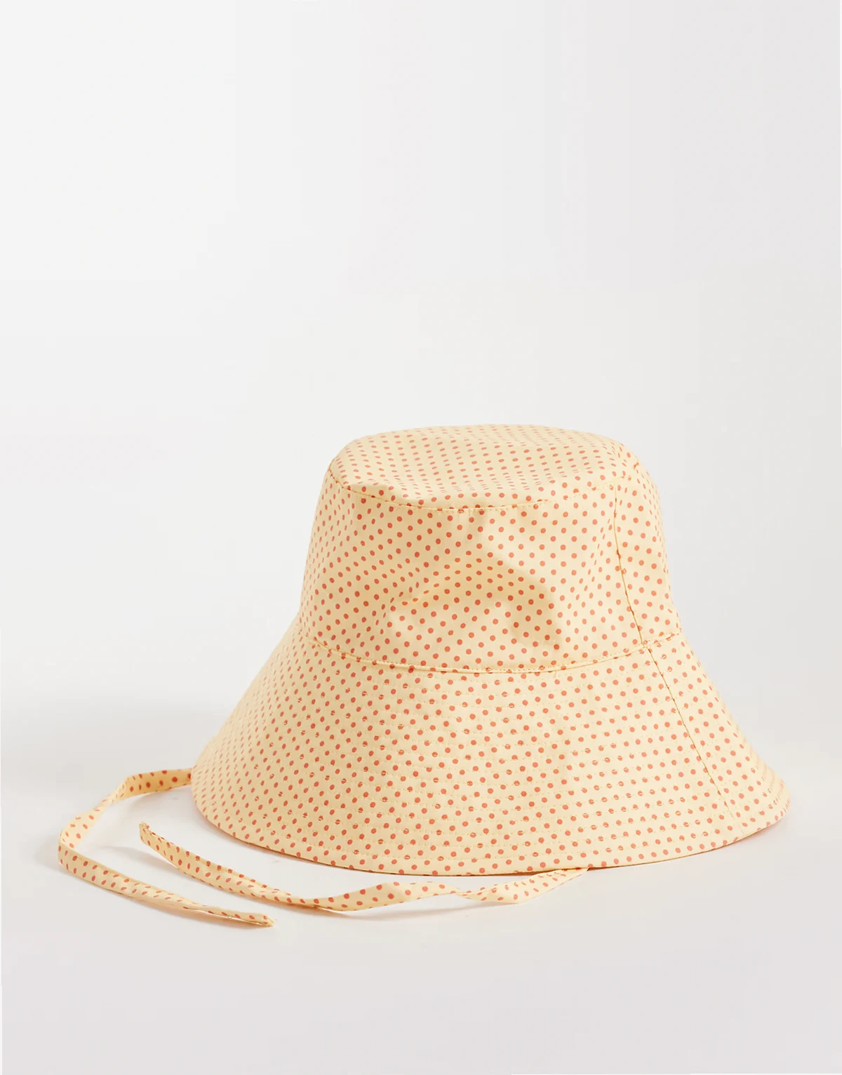 bucket hat with ties in yellow and red polka-dot print