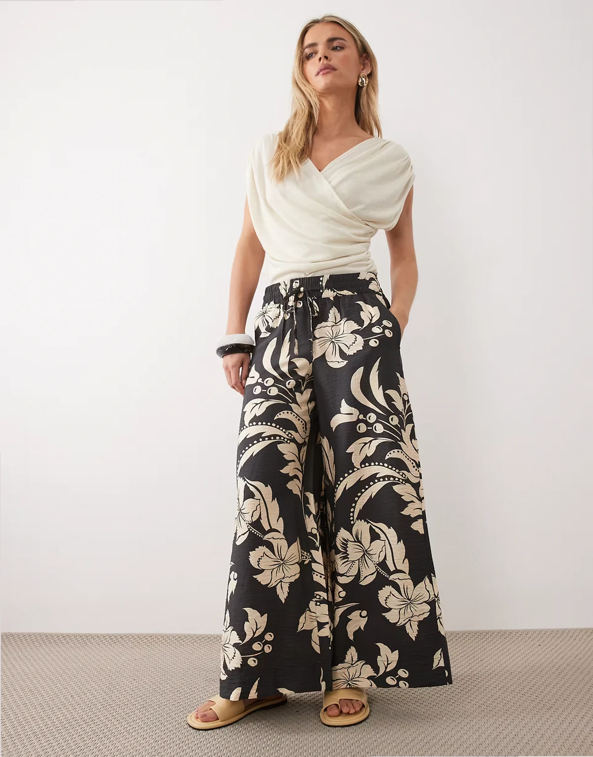 – Hose in Schwarz mit weitem Bein und cremeweißem Blumenmuster