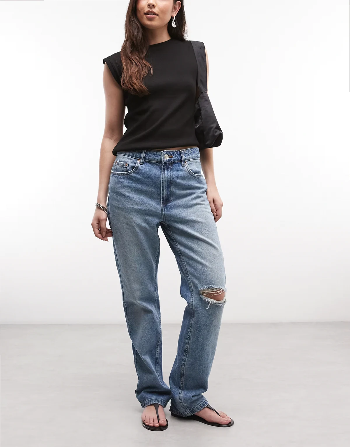 – Jasnoniebieskie jeansy o prostym kroju w stylu lat 90 z rozdarciami
